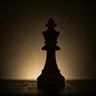 Silhouette of a chess king piece against a dark background